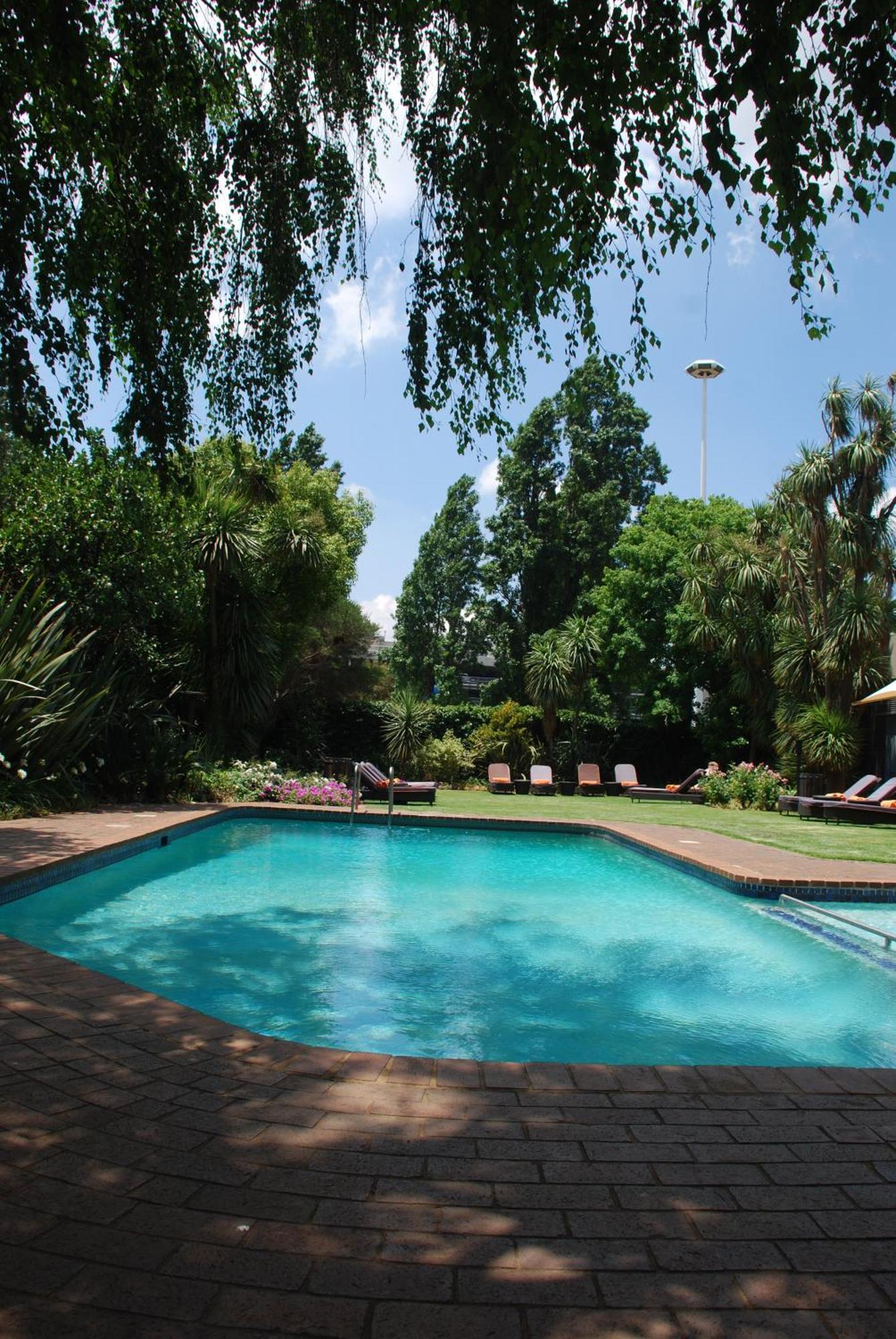 Southern Sun Or Tambo International Airport Hotel Kempton Park Buitenkant foto The garden and swimming pool at the residence